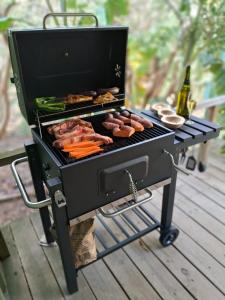 una parrilla con carne y verduras y una botella de cerveza en Cañas y Mar - A 70m del mar, en Cuchilla Alta