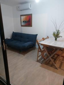 sala de estar con sofá azul y mesa en Cañas y Mar - A 70m del mar, en Cuchilla Alta