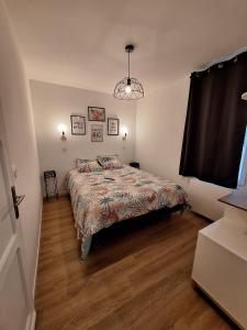 a bedroom with a bed with a comforter and a window at La Pinède du Chéou in Mimizan