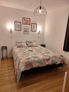 a bedroom with a bed with a colorful bedspread at La Pinède du Chéou in Mimizan