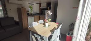 a small table and chairs in a small kitchen at LJ Cosy Lodge - Mobilhome in Houlgate