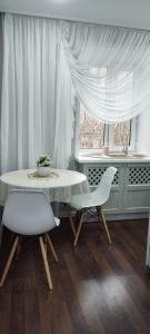卡拉干達的住宿－Люкс в центре Караганды，一间带桌子和两把椅子的用餐室以及窗户。