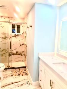 a bathroom with a shower and a toilet and a sink at CozyHome in Markham
