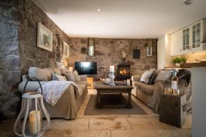 a living room with two couches and a table at Nether Glenny Farm in Stirling