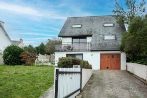 une maison blanche avec un portail et une allée. dans l'établissement Bellevue rue de la petite corniche, à Perros-Guirec