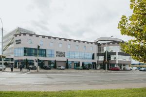 a large white building on a street corner with cars parked at Hotel Select in Sibiu