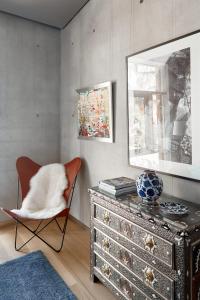 a living room with a dresser and a chair at Ola Foundation Residence in Rīga