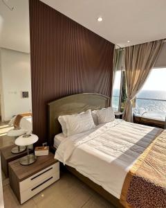 a bedroom with a large bed and a window at برج داماك الجوهرة جدة , الجناح الذهبي-Damac jawharah tower in Jeddah