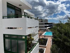 an apartment building with a balcony and a swimming pool at Playa Ingles central cozy apartment in Maspalomas