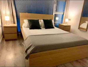 APARTAMENTO EXCLUSIVO EN EL CASCO HISTORICO في ألميريا: غرفة نوم بسرير كبير مع مواقف ليلتين