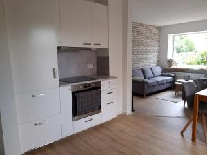een keuken met witte kasten en een woonkamer bij Unterkunft - Alte Hofstraße - in Damlos