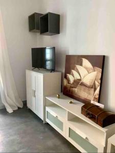 APARTAMENTO EXCLUSIVO EN EL CASCO HISTORICO في ألميريا: غرفة معيشة مع تلفزيون وخزانة بيضاء