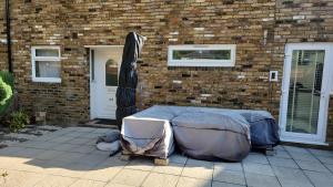 a bed in front of a brick building at West Dulwich Home 28 Mins to London Victoria in London