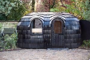 een klein houten huis met een raam in een tuin bij B'Guest Sleep & Retreat in Brugge