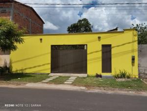 um edifício amarelo no lado de uma rua em Temporada Casa dos Paiva em Barreirinhas