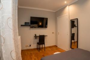 Zimmer mit einem Tisch und einem TV an der Wand in der Unterkunft RoofRhome in Rom