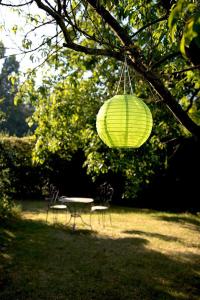 a table and chairs and a lantern hanging from a tree at Nokernote in Tienen