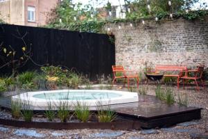 un bain à remous dans un jardin avec des chaises et une table dans l'établissement B'Guest Sleep & Retreat, à Bruges