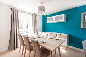 uma sala de jantar com paredes azuis e uma mesa e cadeiras em Homely 4BD Townhouse - Next to Hanley Park em Stoke-on-Trent