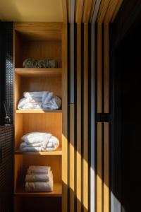 um armário com prateleiras de madeira com toalhas em HORIZONS of Bakurtsikhe em Bakurtsʼikhe