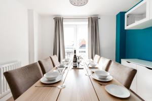 uma sala de jantar com uma mesa de madeira e cadeiras em Homely 4BD Townhouse - Next to Hanley Park em Stoke-on-Trent