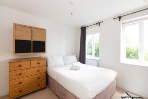 a bedroom with a bed and a dresser and windows at Homely 4BD Townhouse - Next to Hanley Park in Stoke on Trent