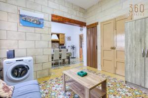 a living room with a washing machine and a table at A lovely, 1BR home with lovely views in Isla BY 360 Estates in Senglea