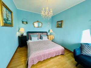 a blue bedroom with a bed and a couch at Esmaraldas House of Love in Terrasini