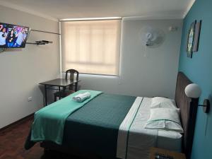 um quarto com uma cama com um cobertor verde e uma janela em Dream Place Trujillo em Trujillo