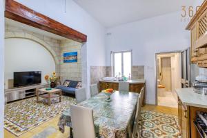 a kitchen and a living room with a table and a couch at A lovely, 1BR home with lovely views in Isla BY 360 Estates in Senglea