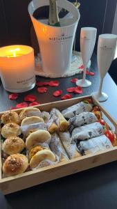 una bandeja de comida en una mesa con una vela y vasos en La suite M en Verviers