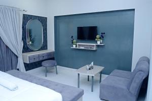 Habitación con cama, espejo y TV. en Pakistan Club Inn Hotel, en Kalar Goth