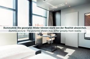 - une chambre avec un lit et une table dans l'établissement B&B Hotel Erfurt City-West, à Erfurt