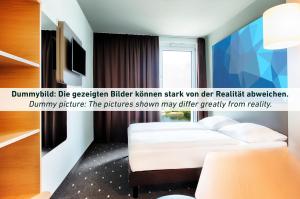 エアフルトにあるB&B Hotel Erfurt City-Westの白いベッドと窓が備わるホテルルームです。