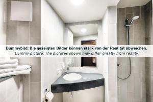 ein Bad mit einem Waschbecken und einer Dusche in der Unterkunft B&B Hotel Erfurt City-West in Erfurt