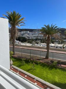 a view of a street with palm trees and a road at Tobago215 in Puerto Rico de Gran Canaria