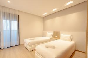 丹吉爾的住宿－Luxury Apartments，酒店客房设有两张床和窗户。