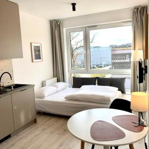 sypialnia z 2 łóżkami i stołem oraz kuchnia w obiekcie Platon Residence Apartments w Łodzi