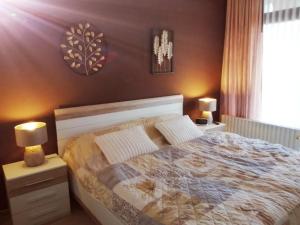 a bedroom with a bed and two lamps and a window at Ferienwohnung Mogwitz mit Schwimmbad und Saunanutzung in Bad Harzburg