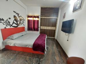 a bedroom with a bed and a flat screen tv at Ratnagiri Homestay in Chikmagalūr