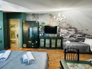 a living room with two beds and a tv at Hotel Zerta Old Tbilisi in Tbilisi City