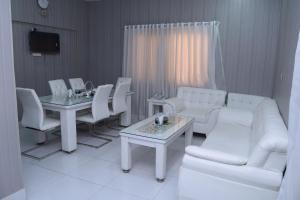 una sala de estar con muebles blancos y un sofá y mesas blancos. en Pakistan Club Inn Hotel, en Kalar Goth