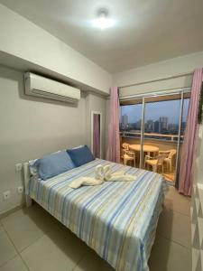 a bedroom with a bed and a balcony with a table at Apt Lindo e Completo no centro in Belém