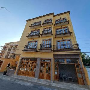 a tall yellow building with windows and balconies at Cancun International Suites in Cancún +36 photos
