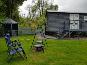 a playground in a yard with a chair and a swing at Braeside Shepherd's Hut - Greenhead - Hadrian's Wall - Northumberland in Greenhead