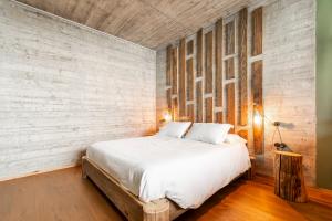 una camera con un grande letto e un muro di mattoni di Chalet Palù a Brosso