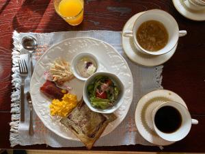 ein Teller mit Speisen, Sandwiches und eine Tasse Kaffee in der Unterkunft 田舎庵 in Hanyu