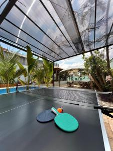 two ping pong paddles on a ping pong table at Éden Pampulha - Hotel Coworking in Belo Horizonte