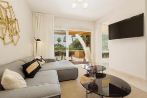 a living room with a couch and a table at Luxurious frontline golf apartment in Elviria in Marbella