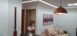 a living room with a chair and a table at Lindo apartamento no Litoral Norte in Camaçari